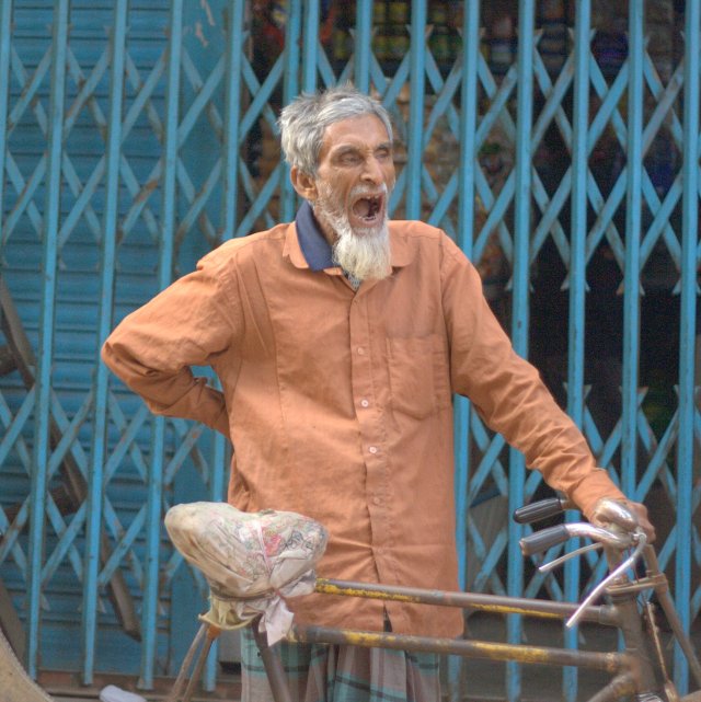 Tired? Rickshaw walla caught during a big yawn.