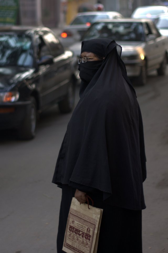 Lady waiting to cross the street.