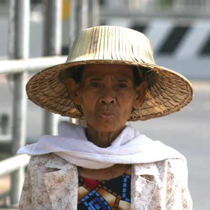 Lady beating the heat with a hat.