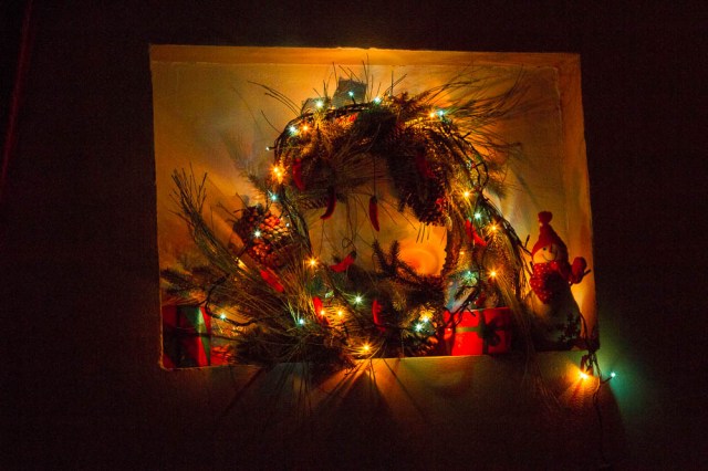 A wreath with lights wrapped around it. This is in our living room!