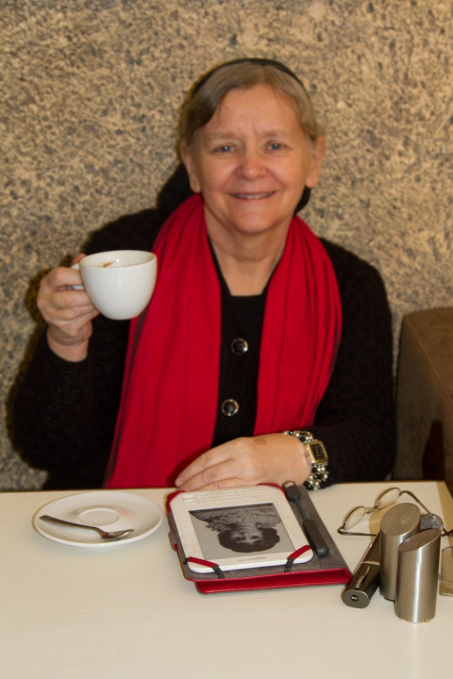 Happy with her Americano coffee while reading on her Kindle!