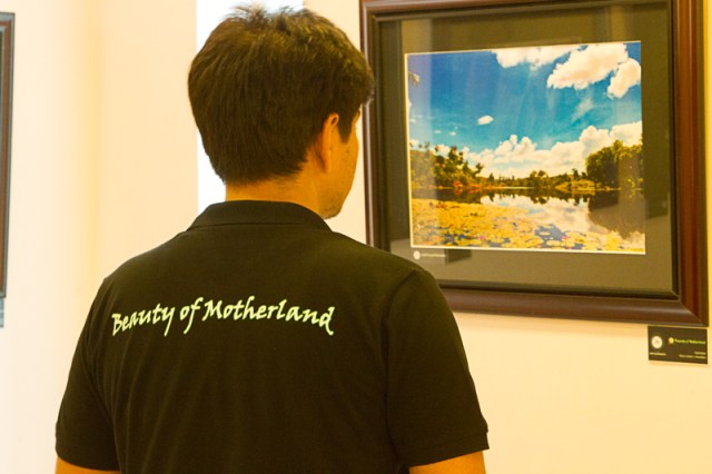 Rong Photo Club Exhibit participant checking out a photo.