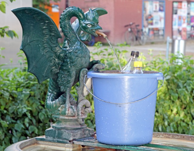 Cooling their drinks at the water fountain.